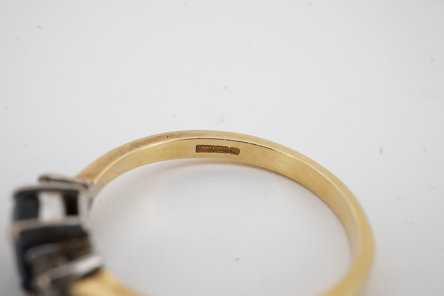 A modern 18ct gold, single stone sapphire and two stone diamond set ring, size O, an 18k, sapphire and diamond set oval cluster ring, size M/N and an 18ct, single stone sapphire and two stone diamond chip set navette sha